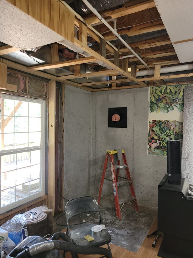 Basement corner torn out down to the foundation with the stovepipe hole