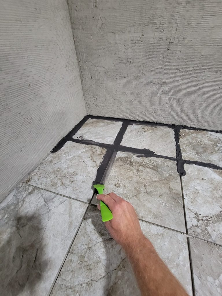 Grouting the gray tile on top of the raised hearth