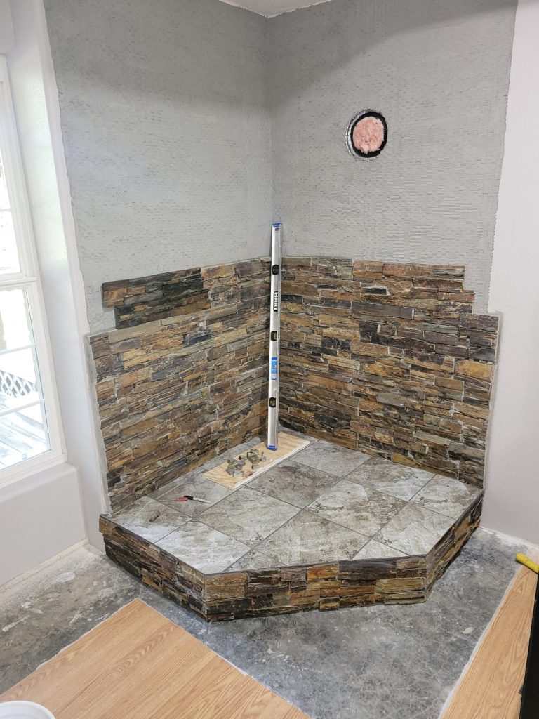 Setting rows of slate stone panels behind the wood stove