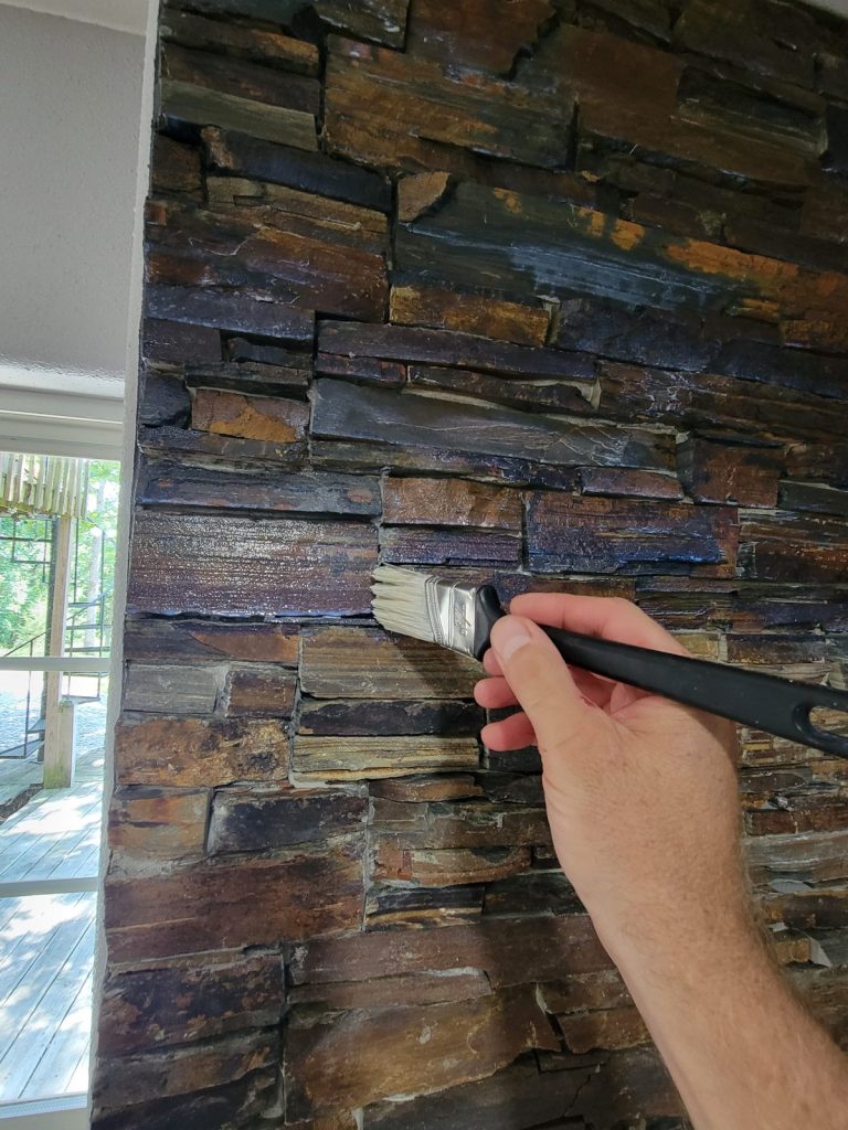 Brushing sealer onto the finished slate stone wall
