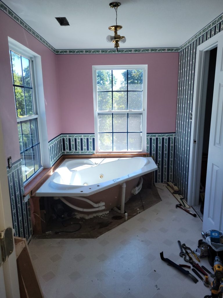 Jack and Jill bathroom before remodel with pink walls, wallpaper border and corner jet tub