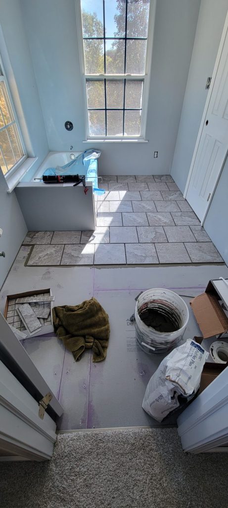 Laying gray floor tile over backer board in the bathroom