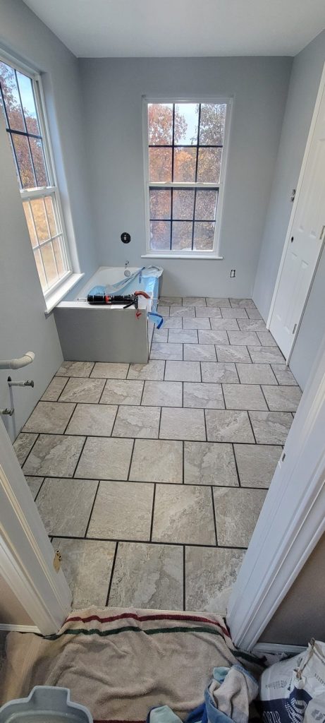 Finished gray tile bathroom floor before grout cleanup