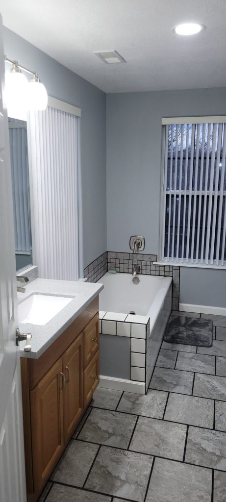 After photo of remodeled Jack and Jill bathroom with vanity and tiled tub